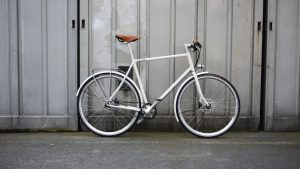 white bike propped up against wall