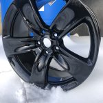 Black powder coated wheel in snow - close up
