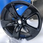 Wheel coated in super wet black powder sitting in snow